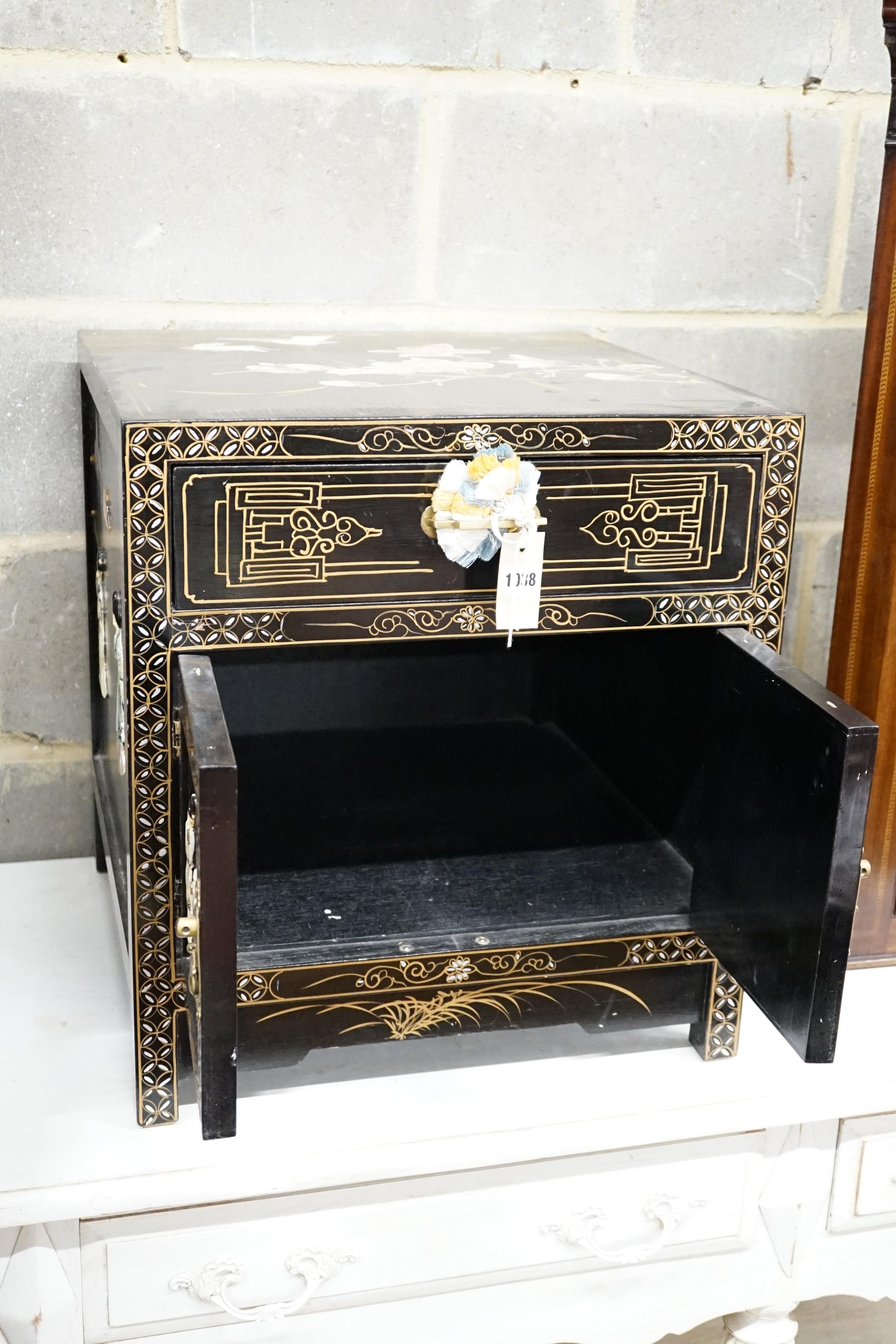 A Chinese black-lacquered brass-mounted small two-door cabinet, the door panels decorated with figures, width 51cm, depth 51cm, height 56cm.